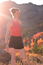 Woman in athletic wear standing in a mountainous area with autumn foliage